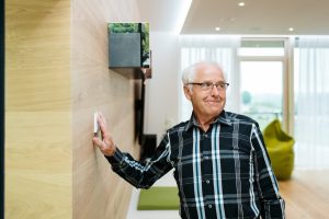 älterer Herr betätigt Smart-Home-System